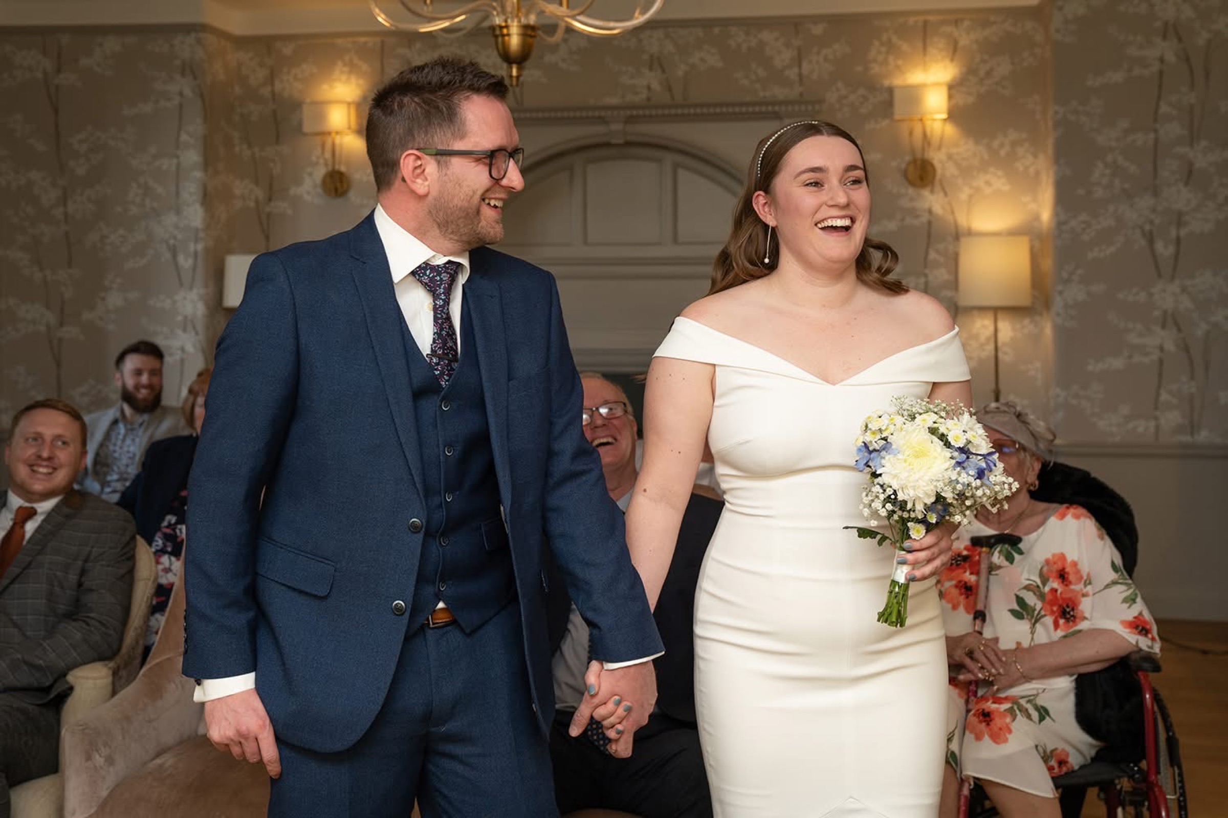 Couple walking out of their ceremony laughing — pure, unposed joy