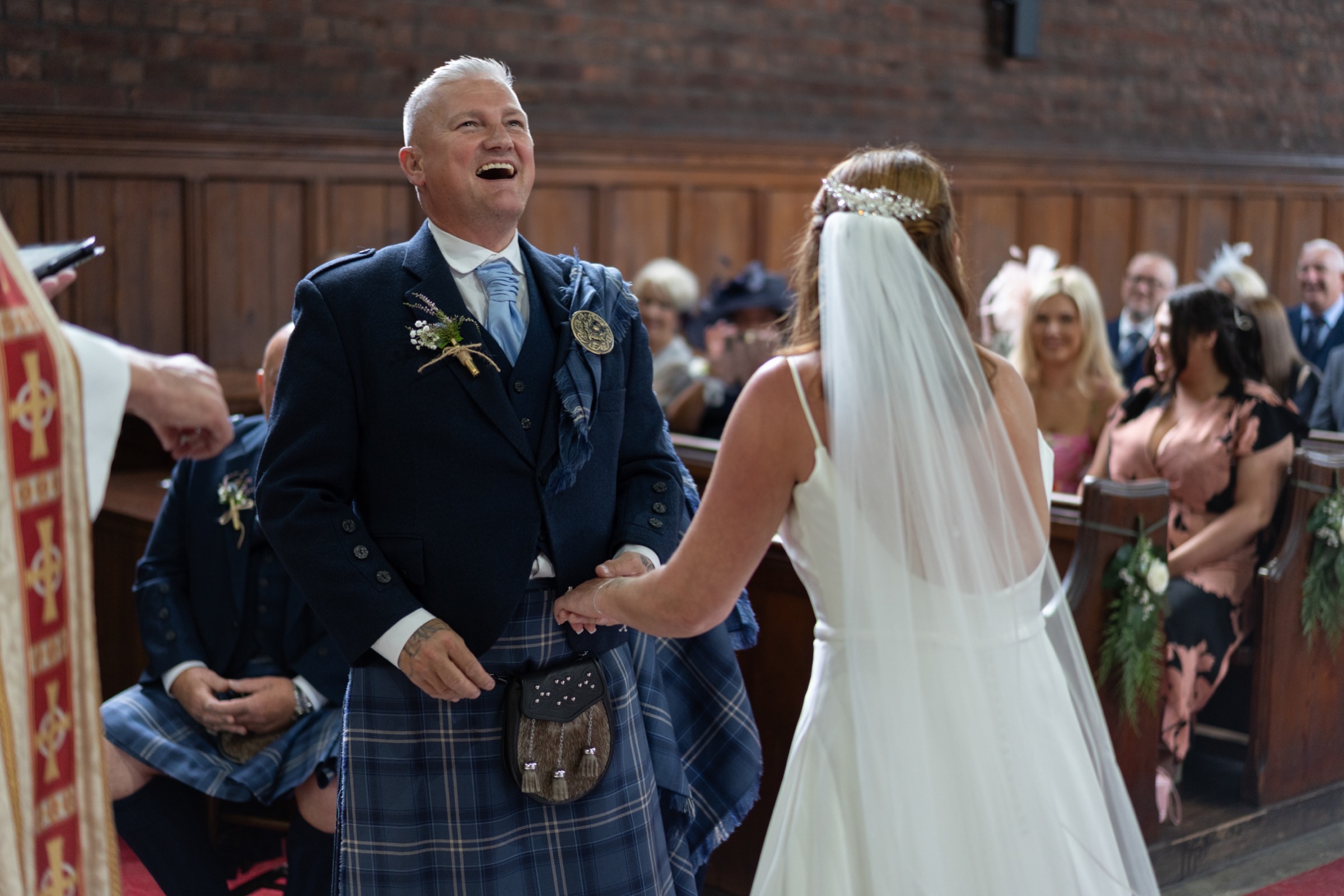 The groom erupts with laughter the moment he sees his bride walking down the aisle