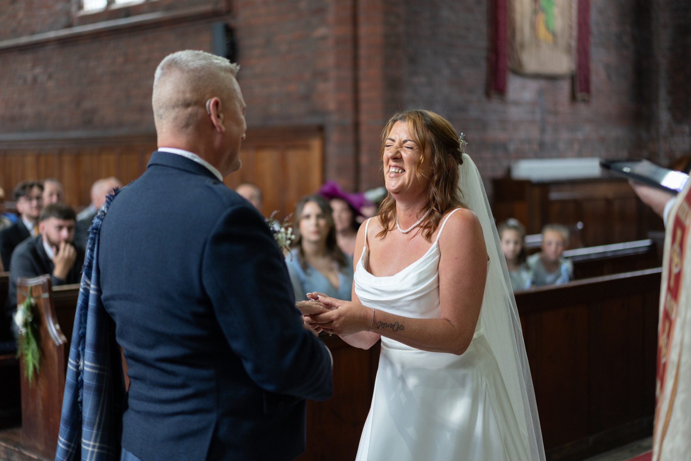 A bride breaks into genuine laughter during the ceremony — real, unposed, impossible to direct